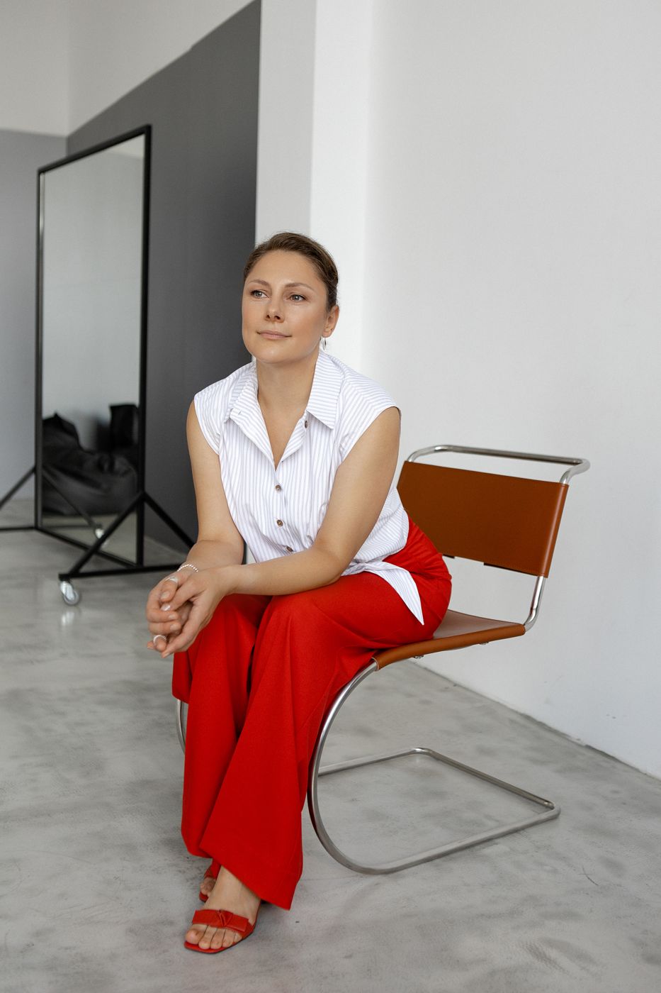 Volha seated on a leather chair, looking thoughtfully to the side
